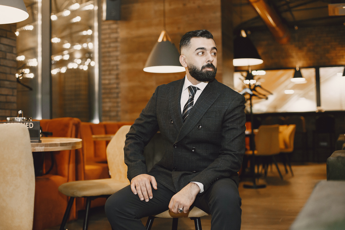 Handsome international man. Businessman working in a cafe. Guy with a beard.