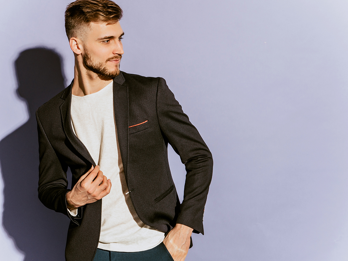 Portrait of handsome confident hipster lumbersexual businessman model wearing casual black suit. Fashion stylish man posing in studio